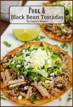 pork and black bean tostadas are served on tortilla shells with garnishes