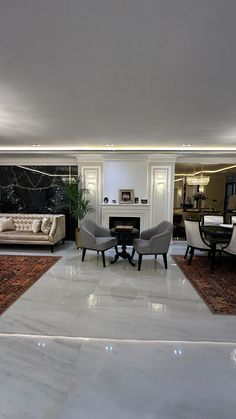 a living room filled with furniture and a fire place next to a dining room table