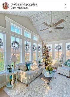 a living room filled with furniture and a christmas tree in the middle of the room