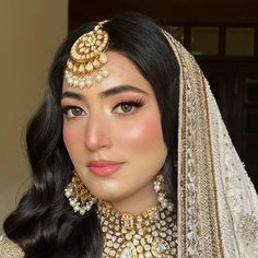 a woman wearing a bridal outfit and jewelry