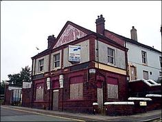 an old brick building on the corner of a street with boarded up windows and doors