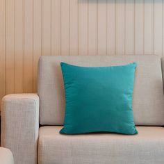 a blue pillow sitting on top of a white couch