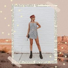 a woman standing in front of a white brick wall wearing a hat and dress with stars on it