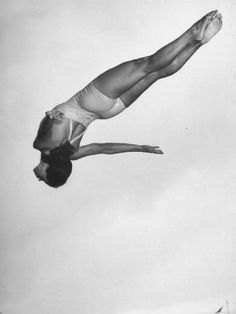 a man diving in the air while holding onto a surfboard