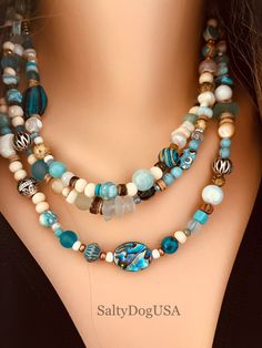 a close up of a necklace on a mannequin neckline with beads and charms