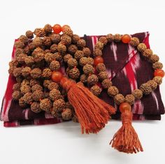 Beads: Rudraksha seedsStone: CarnelianMeaning: Courage, vitality and sexual energyChakra: Sacral (2nd)Tassel: Ahimsa silk, cruelty-free Bohemian Red Mala For Gift, Brown Hand Knotted Mala As Gift, Gift Brown Hand Knotted Mala, Brown Hand-knotted Mala As Gift, Bohemian Mala For Festivals Gift, Bohemian Mala For Festivals As Gifts, Good Energy, Cruelty Free