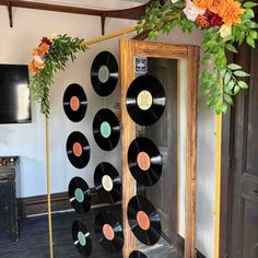 there are many records on the wall in this room with flowers hanging from it's sides