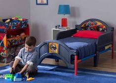 a young boy playing with his toys in the bedroom