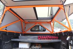 the inside of an orange and white truck with its bed in the back ground area