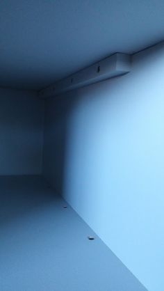 an empty room is shown with only the light coming from the window on the far wall