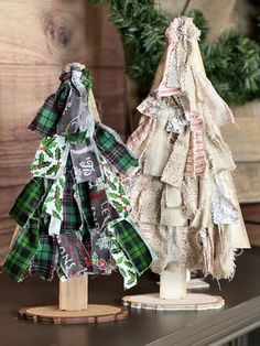 two wooden christmas trees sitting on top of a table next to each other and decorated with ribbons