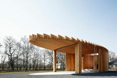 an open air pavilion with wooden slats on the roof