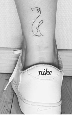 a woman's foot with a small tattoo on the ankle that reads, nike