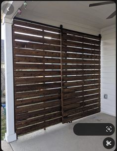 a large wooden sliding door on the side of a house