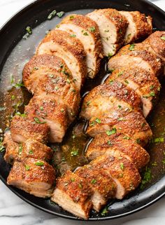 pork chops in a skillet with parsley on top