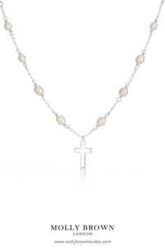 Designed using freshwater pearls the Cross on Pearl Station Necklace features a sterling silver cross set on the 16" freshwater pearl necklace adjusted at 14" to fit most ages. The cross measures 10mm in width 2mm in depth and a total drop of 15mm sitting delicately upon the pearls. This necklace would make a beautiful gift for a Baptism or Holy Communion. #holycommuniongift #holycommunionjewelry #holycommuniongiftgirls #girlsrosary #girlscross #childrensjewelry #mollybrownlondon # pearlcross Silver Cross Necklace With Pearl Chain As Gift, Pearl Drop Necklace With Cross Pendant For Gift, Pearl Drop Cross Pendant Necklace As Gift, Pearl Drop Necklace With Cross Pendant As Gift, Cross Pendant Necklace With Pearl Drop Gift, Pearl Cross Necklace With Pearl Drop As Gift, Silver Cross Necklace With Pearl Chain For Gift, Silver Cross Pendant Pearl Necklace As Gift, Silver Cross Necklace With Pearl Drop