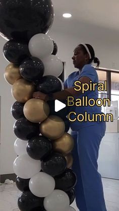 a woman standing next to a giant balloon column in an office building with the words spiral balloon column written on it