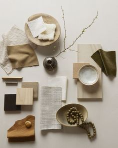 various objects are arranged on a table with white paper and wood pieces in the middle