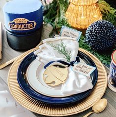 a place setting with blue and gold plates, napkins, and other holiday decorations