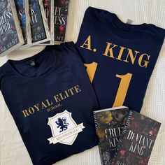 three books and two t - shirts on a bed