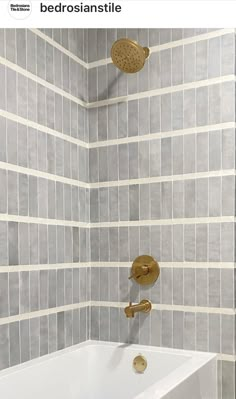 a white bath tub sitting under a faucet next to a wall mounted shower head