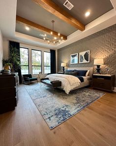 a large bedroom with hardwood floors and gray walls, along with an area rug on the floor