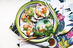 a plate filled with food and chopsticks on top of a floral table cloth