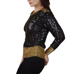 Saint Laurent Rive Gauche, created a gorgeous, hand-beaded, black and gold silk evening top with long sleeves. The black sequins are iridescent, the gold sequins and beads are meticulously added to the shoulders, waist line and cuffs of this silk top. There are two zippers on both sides of the vintage sparkle top so one may enter easily. Also are shoulder pads, easily removable. Made in France. Designer: Saint Laurent. In 1966, Yves Saint Laurent opened a ready-to-wear boutique in Paris called “ Long Sleeve Sequin Top For Celebration, Gold Sequin Tops For Celebration, Gold Embellished Evening Blouse, Gold Sequin Top For Celebration, Gold Sequin Blouse For Night Out, Fitted Sequin Winter Blouse, Festive Long Sleeve Top With Contrast Sequins, Gold Long Sleeve Blouse With Sequins, Fitted Gold Sequin Blouse