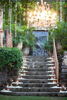 an outdoor staircase with chandelier hanging from it's ceiling and stone steps leading up to the entrance