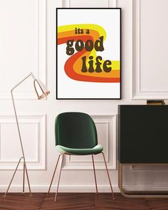 there is a green chair next to a white wall with a poster on it that says, it's a good life