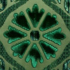 a close up view of a green and black fabric with an intricate design on it