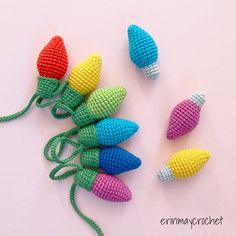 crocheted christmas lights are lined up on a white surface with the string attached to them