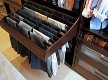 an open drawer with clothes hanging on it