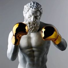 a statue of a man with two boxing gloves on his chest and one hand in the air