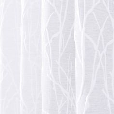 white curtains with branches drawn on them in front of a window sill, close up