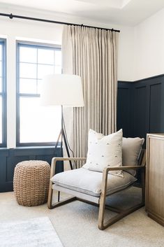 a living room with a chair, lamp and window