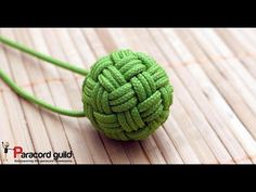 a ball of yarn sitting on top of a wooden floor next to a green string