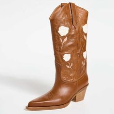 Elevate your style with these tan cowgirl boots featuring rose embroidery, a chunky heel, and a pointy toe. Perfect for adding a touch of western flair to any outfit. Color: Tan Heel Type: Chunky heel Heel height: 2.25" / 55 mm approx Shaft height: 11.5'' / 290 mm approx Product measurements were taken using size 8. Please note that measurements may vary by size. Toe: Pointed toe Embroidered roses and western stitching design Handcrafted US sizing. Fits true to size. Tan Cowgirl Boots, Embroidered Chunky Heels, Cowboy Shoes, Dance Heels, Embroidered Roses, Suede Boots Knee High, Tan Heels, Rose Embroidery