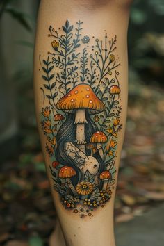 a woman's leg with an artistic tattoo design on it, featuring mushrooms and flowers