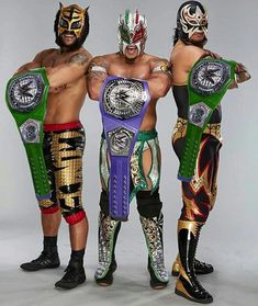 three men standing next to each other wearing wrestling gear