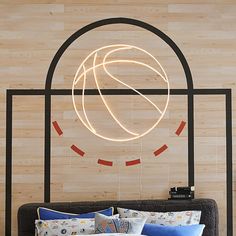 a bed with a basketball on the headboard and lights hanging from it's side