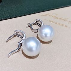 Highlight: Aurora Luxury South Sea Pearl Earrings Product Information OriginSouth Sea Pearl Jewelry Processed in Japan MaterialSouth Sea Pearl, 18k Gold, and Natural Diamonds DimensionsLength Approx. 2.5 cm Pearl Shaped: Round Size: 14 mm Quality: AAAA Nacre: Very Thick Color: White Luster: Aurora Accessories Metal: 4.0 g of 18k White Gold Other: 1.00 ct of SI Quality Natural diamonds Luxury White Diamond Earrings For Formal Occasions, Luxury White Sterling Silver Pearl Earrings, Luxury White Pearl Earrings In Sterling Silver, Luxury White Diamond Earrings In Sterling Silver, Luxury White Round Pearl Earrings, Luxury Pearl White Formal Earrings, Luxury Pearl White Earrings For Formal Occasions, Luxury Pearl White Earrings For Pierced Ears, Pearl White Diamond Earrings Fine Jewelry