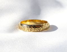 a gold wedding ring sitting on top of a white cloth