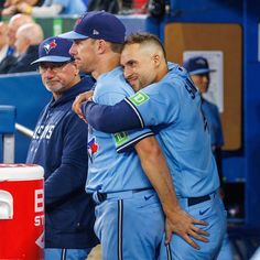 two baseball players hugging each other in the dugout