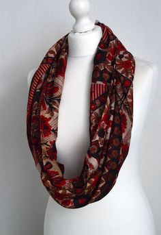 "This stunning boho scarf has a vibrant floral design in red black and cream to make a silk infinity scarf suitable as a gift for any woman. This light weight scarf has been sewn from a pure silk sari to make this sophisticated silk scarf the perfect fashion accessory. This infinity scarf has been sewn from a vintage pure silk sari to make a lovely, simple to wear accessory: just wrap it twice or three times around your neck, or fold in half & slip one end through the other - a versatile acc Bohemian Scarves With Floral Print, One Size, Bohemian Floral Print Scarves For Festivals, Bohemian Patterned Scarves For Fall, One Size Bohemian Scarves With Floral Print, One Size Bohemian Scarf With Floral Print, Bohemian One Size Floral Print Scarves, Bohemian One-size Floral Print Scarves, Bohemian Patterned Scarves For Festival, Bohemian Infinity Loop Scarf