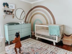 a child's room with a baby crib, dresser and rug in it