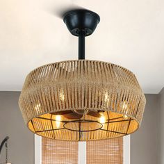 a chandelier hanging from the ceiling in a room with blinds on the windowsill