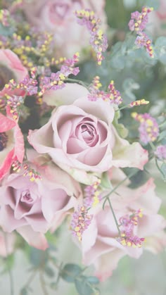 a bunch of pink roses with green leaves and purple flowers in the middle, surrounded by greenery