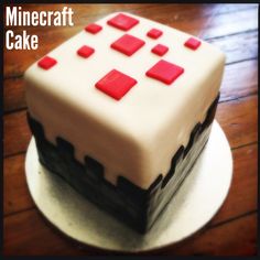 a white and red cake sitting on top of a wooden table