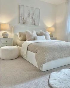 a white bed sitting in a bedroom next to two lamps on either side of the bed